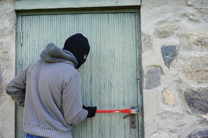 Thief breaking into a container to steel work tools